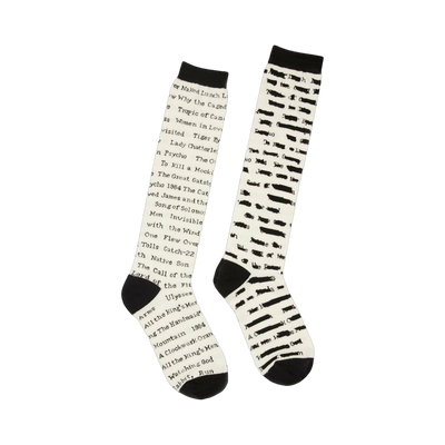 Pair of cream knee-high socks with black text listing titles of banned books.  A literary-themed design for book lovers.