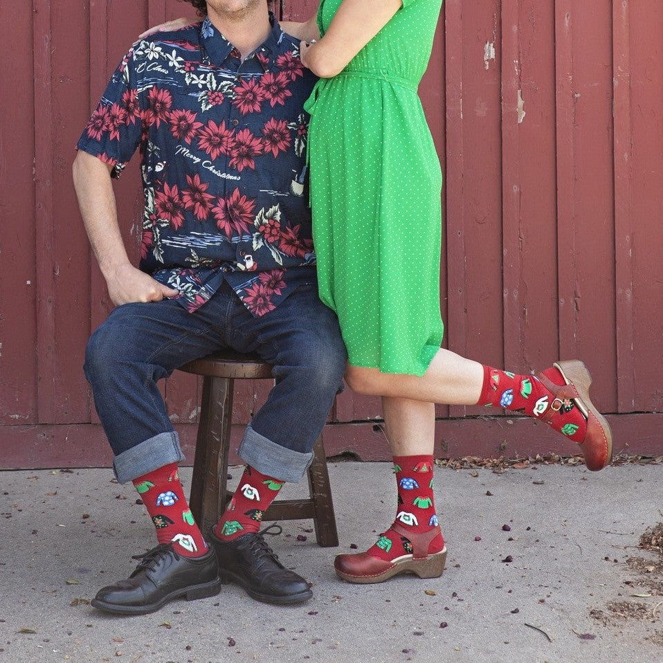 A close-up of Ugly Sweaters socks featuring loud holiday sweater motifs, on a person at a Christmas party. [lf]