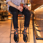 A pair of Bloody Good Drink Bamboo socks in Charcoal Heather crossed at a brunch booth beside a celery-stalk-garnished drink. [lf]