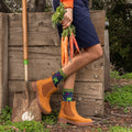 A pair of Carrot Rainbow Bamboo socks in Navy Heather crossed on a rug beside a farmers-market basket. [lf]