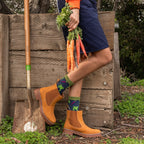 A pair of Carrot Rainbow Bamboo socks in Navy Heather crossed on a rug beside a farmers-market basket. [lf]