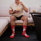 A pair of Crab Rangoon socks in Red stretched across a picnic blanket beside crab rangoon and dipping sauce. [lf]