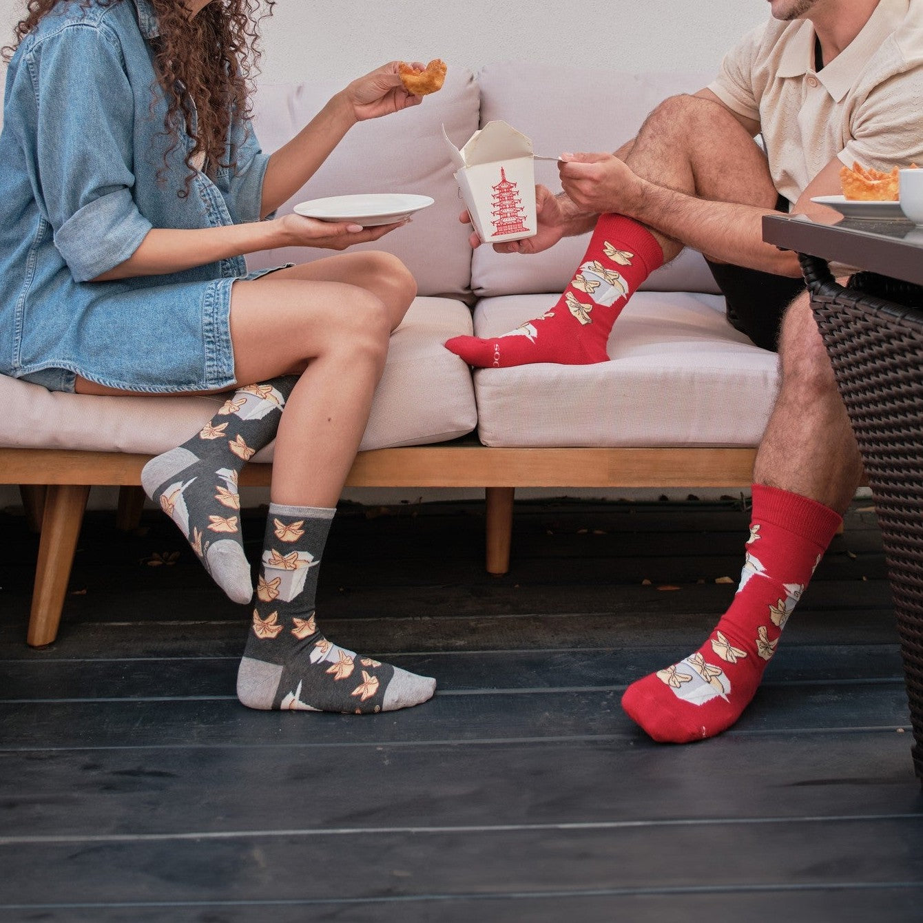 A friend laughs at a dinner table covered in Chinese takeout, her Crab Rangoon socks in Red kicked out. [lf]