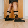 A pair of Dog Gone Stripes Bamboo socks in Hemp resting on a porch swing beside a dozing pug. [lf]