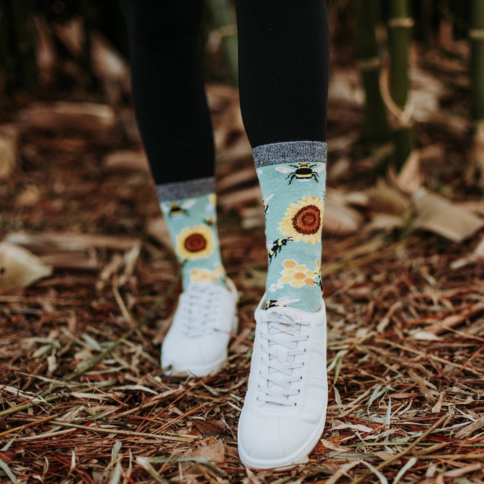Honey In The Bank Bamboo mint socks photographed with white sneakers on a sunlit garden ledge. [lf]