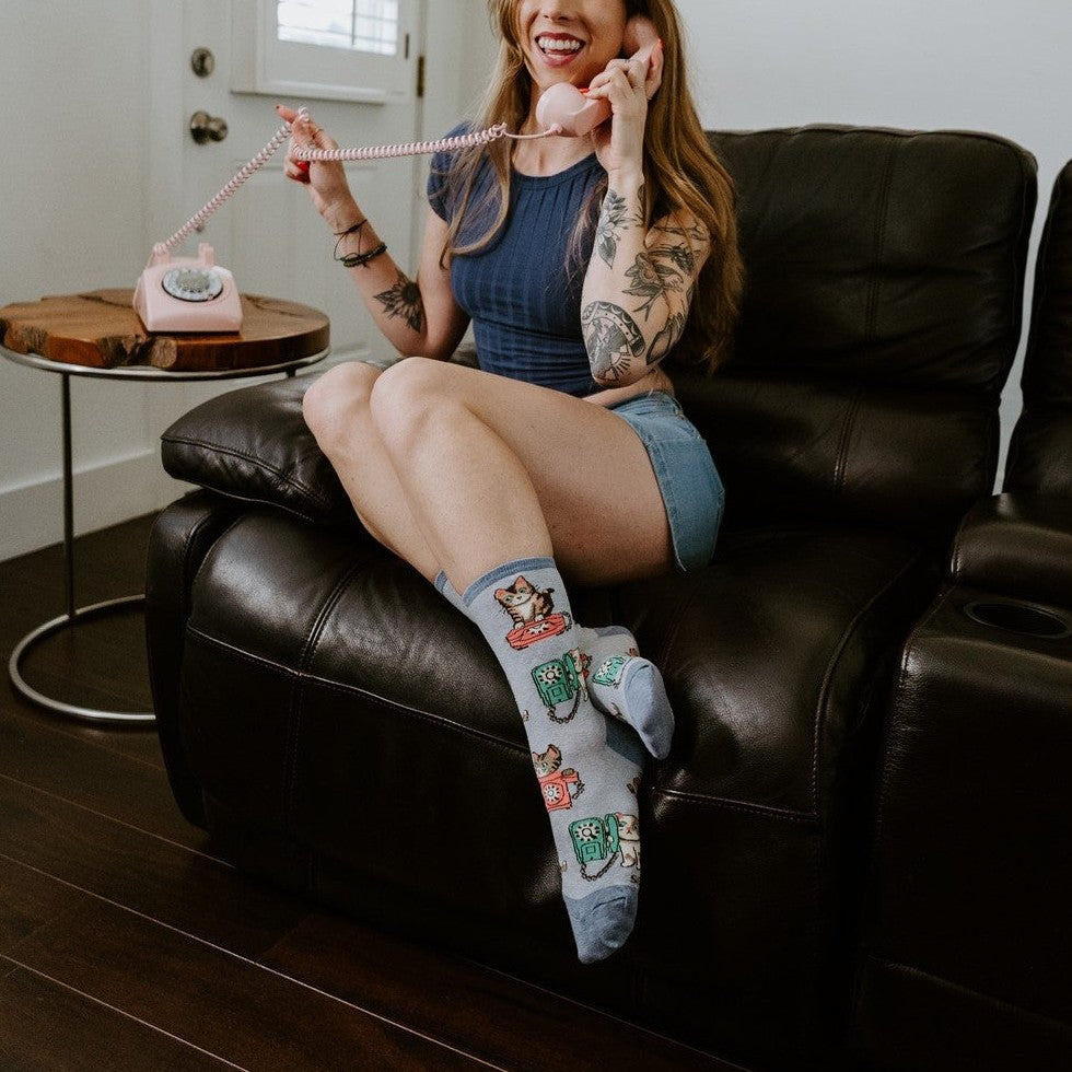 A whimsical interior portrait featuring Cat Calls light blue cat phone socks. [lf]