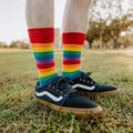A bright lifestyle shot of Pride Stripes rainbow socks worn with athletic shorts and skate sneakers. [lf]