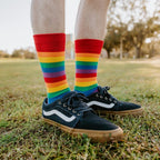 A bright lifestyle shot of Pride Stripes rainbow socks worn with athletic shorts and skate sneakers. [lf]