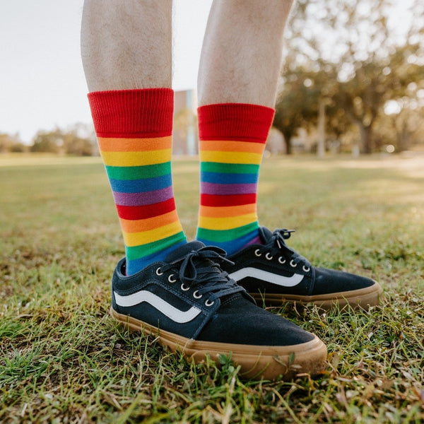 A bright lifestyle shot of Pride Stripes rainbow socks worn with athletic shorts and skate sneakers. [lf]