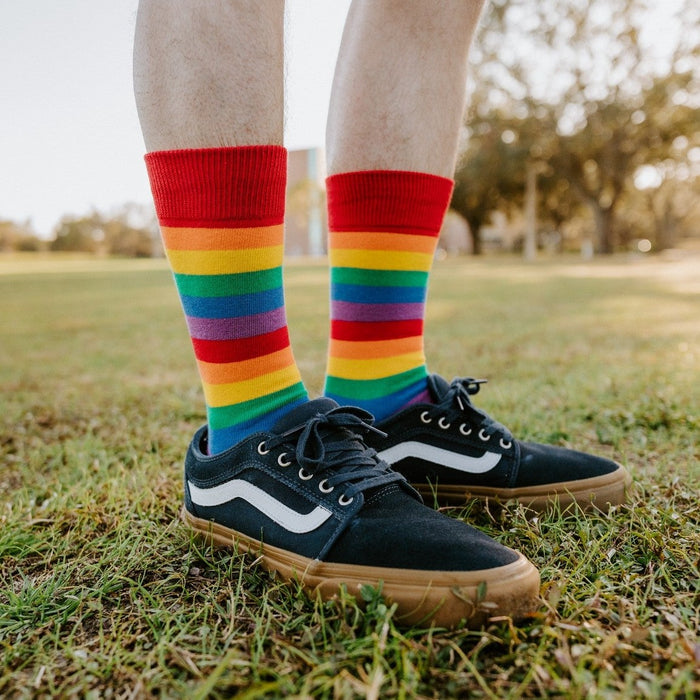 A bright lifestyle shot of Pride Stripes rainbow socks worn with athletic shorts and skate sneakers. [lf]