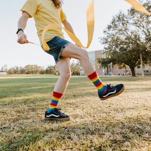 A celebratory portrait featuring Pride Stripes rainbow striped socks and a coordinating rainbow fan. [lf]