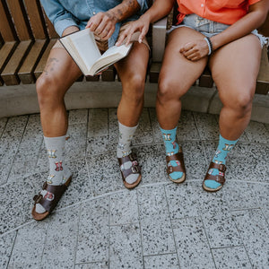Socks And Sandals socks worn with classic leather sandals on a model relaxing on a wooden park bench. [lf]