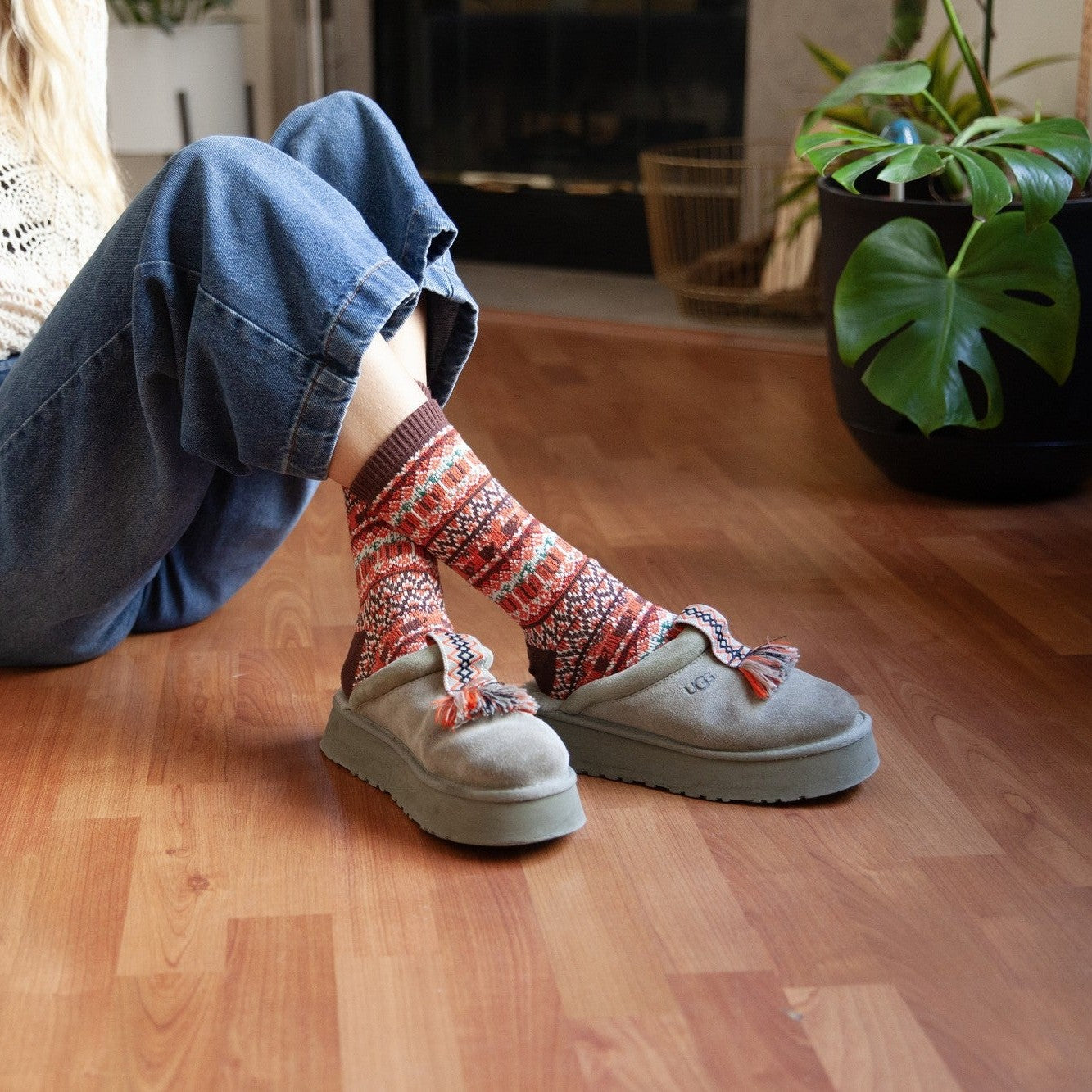 Pumpkin Spice Is Nice fair-isle style socks in autumn colors photographed on bedding for a cozy lifestyle shot. [lf]