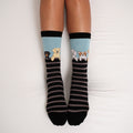 A product flat-lay of Dog Gone Stripes Bamboo socks showcasing the striped knit and dog characters at the cuff. [lf]