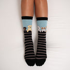 A product flat-lay of Dog Gone Stripes Bamboo socks showcasing the striped knit and dog characters at the cuff. [lf]