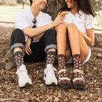Couple laughs together at the base of an oak tree sharing a chanterelle, the pair wearing Colorful Caps Bamboo in Charcoal Heather socks with cuffed pants and shorts. [lf]