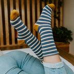 Close-up of two feet pointed upward, highlighting the navy stripes and mustard heel of Sailor Stripe Bamboo socks in Charcoal White. [lf]