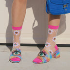[lf] Model wears sheer daisy socks with bright pink cuffs and eye-adorned rainbow heels.