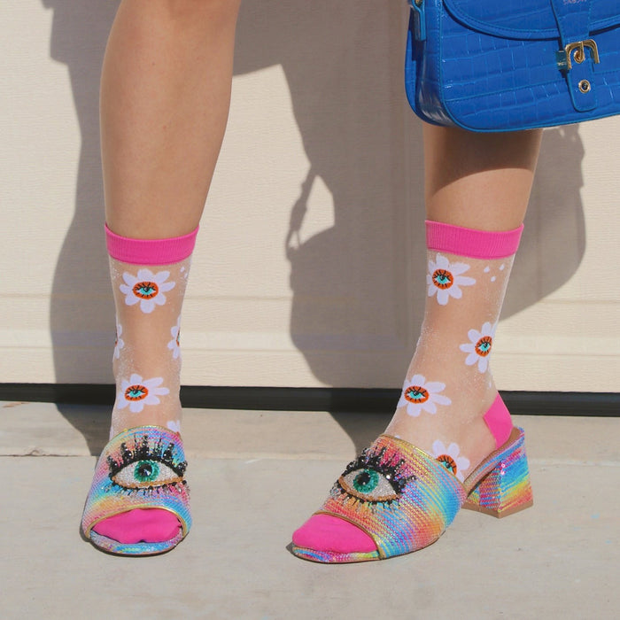 [lf] Model wears sheer daisy socks with bright pink cuffs and eye-adorned rainbow heels.