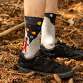 [lf] Astronaut on grey socks pours a universe of planets, surrounded by pinecones.