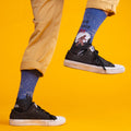 [lf] Person in tan pants and black sneakers, wearing blue Bigfoot socks with a starry night scene.