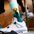 [lf] Person wearing white sneakers and teal socks with a deer and sunset design.