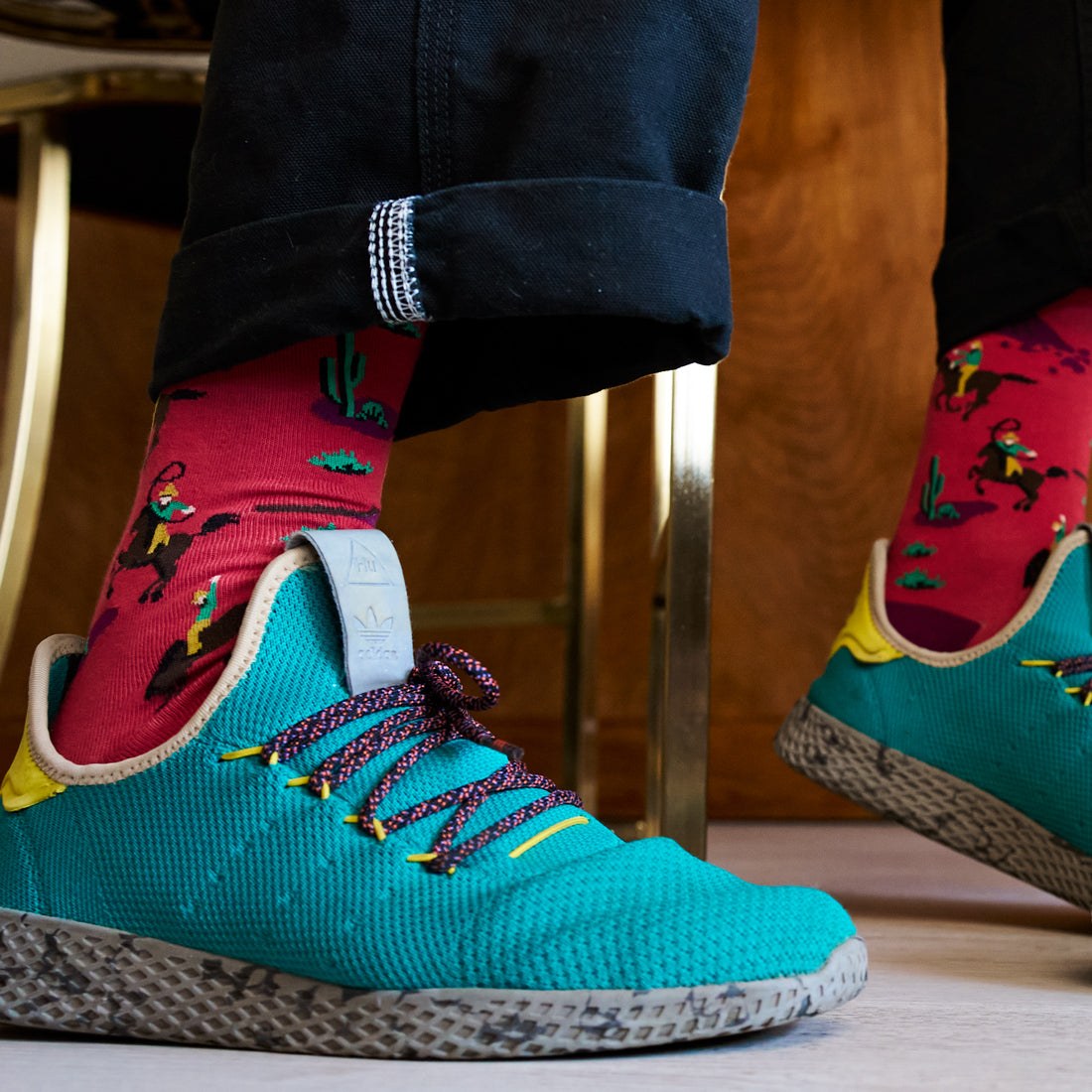 [lf] Red cowboy socks with cacti, worn with black pants and teal sneakers.