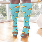 [lf] Model stands wearing blue knee-high socks with taco dinosaur pattern and brown platform heels.