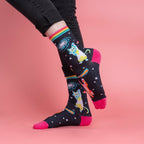 [lf] Person in black jeans models dark socks with space cats, galaxies, and bright pink toes.