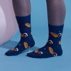 [lf] Legs in grey leggings wearing blue socks with hot dogs and astronaut helmets.