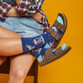 [lf] Person wearing blue socks with duck and umbrella patterns, denim shorts, and Birkenstock sandals.