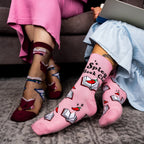 [lf] Two women's legs, one in sheer book-patterned socks, the other in pink "Spicy Book Club" socks.