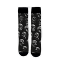 Flat lay showcasing a pair of black crew socks with a skull pattern.