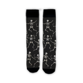 Flatlay image showing a pair of black 'Dead Man's Party' socks with dancing skeletons.