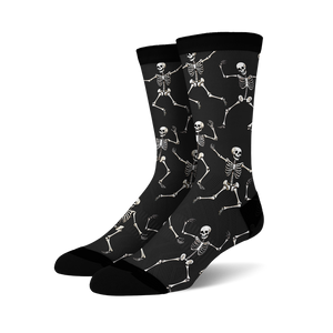 Pair of black crew socks with a fun all-over print of dancing skeletons in off-white.