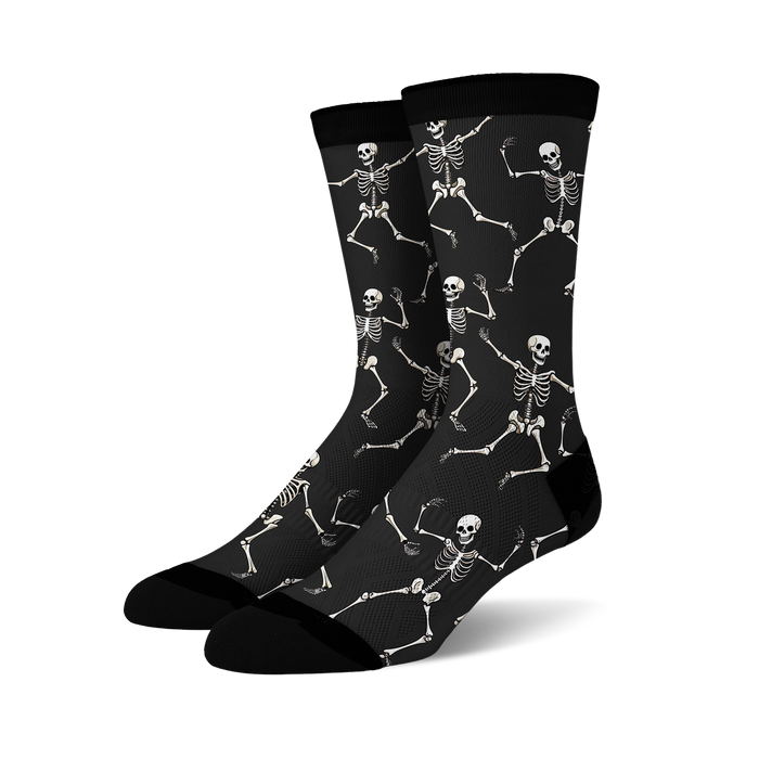 Pair of black crew socks with a fun all-over print of dancing skeletons in off-white.