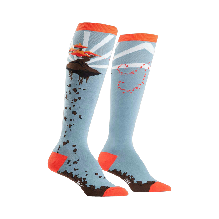 A pair of knee-high socks in light blue, orange, and brown.  One sock shows a flying bonsai tree; the other has a whimsical trail design. }}