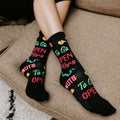 Close detail of crossed ankles on a beige cushion highlighting the To Go, Open 24 Hrs and donut prints on the 24 Hour Diner socks. [lf]