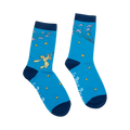 Pair of blue crew socks with navy cuffs.  Features The Little Prince illustration, flock of birds, and gold stars. 