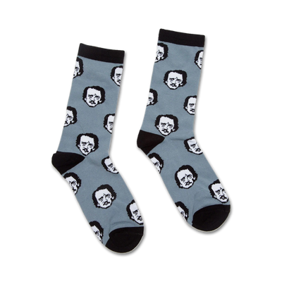 Pair of crew socks in dusty blue with a repeating pattern of Edgar Allan Poe's black and white portrait. Black cuffs and toes.