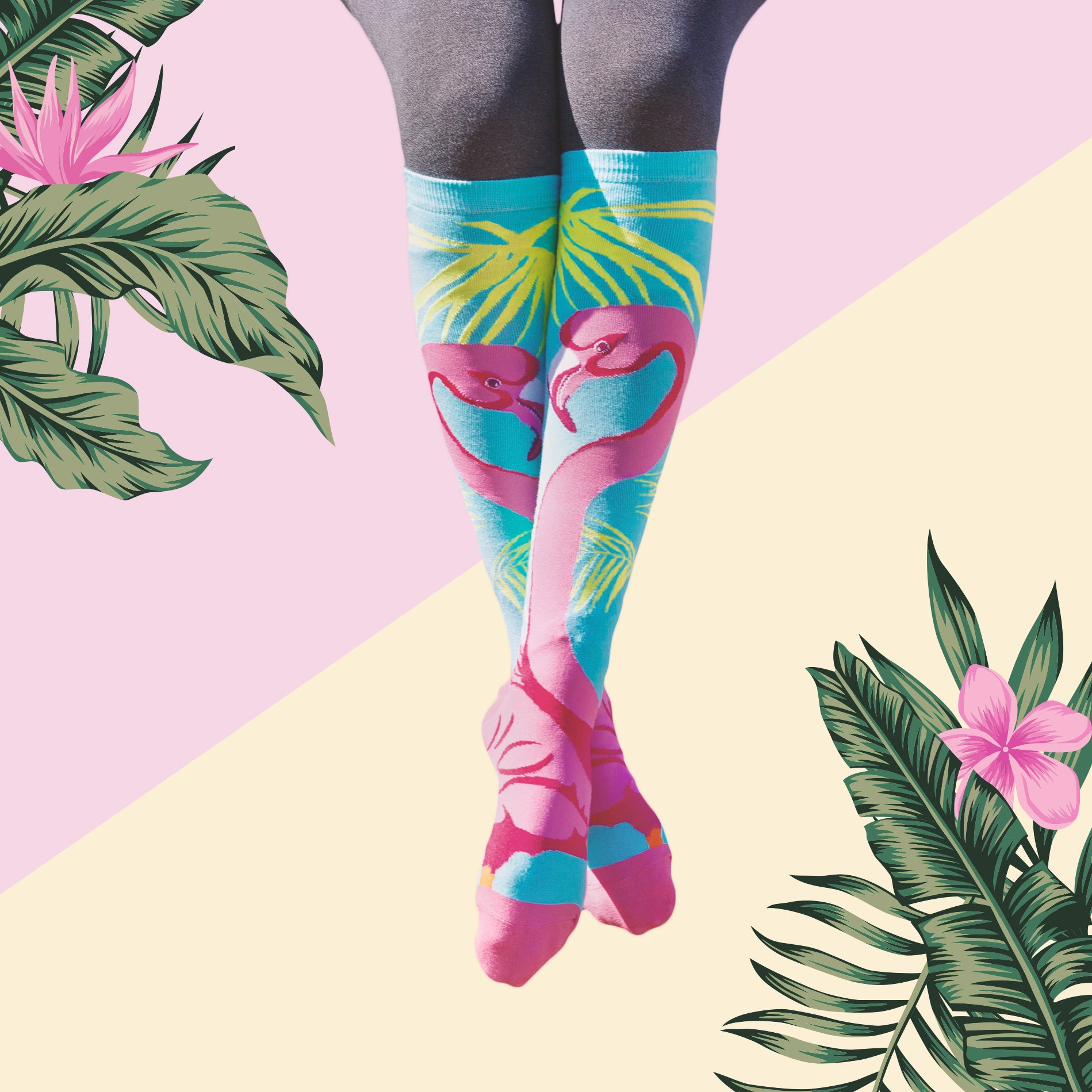 Lifestyle shot of model's legs wearing the flamingo knee-high socks against a tropical-themed background. [lf]