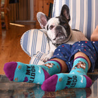 Lifestyle shot of a person's legs with a bulldog resting on a chair and wearing the bulldog socks.