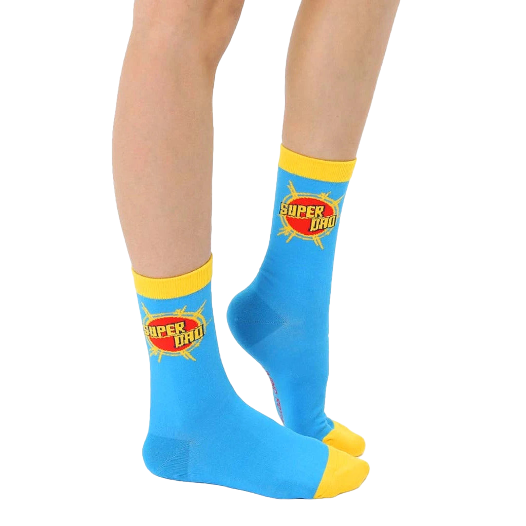 Flat lay of adult 'Super Dad' socks. Blue with yellow cuff and graphic. [lf]