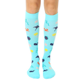 Pair of aqua blue knee-high compression socks.  A whimsical under-the-sea pattern with colorful whales, crabs, starfish, and stingrays is shown. [lf]