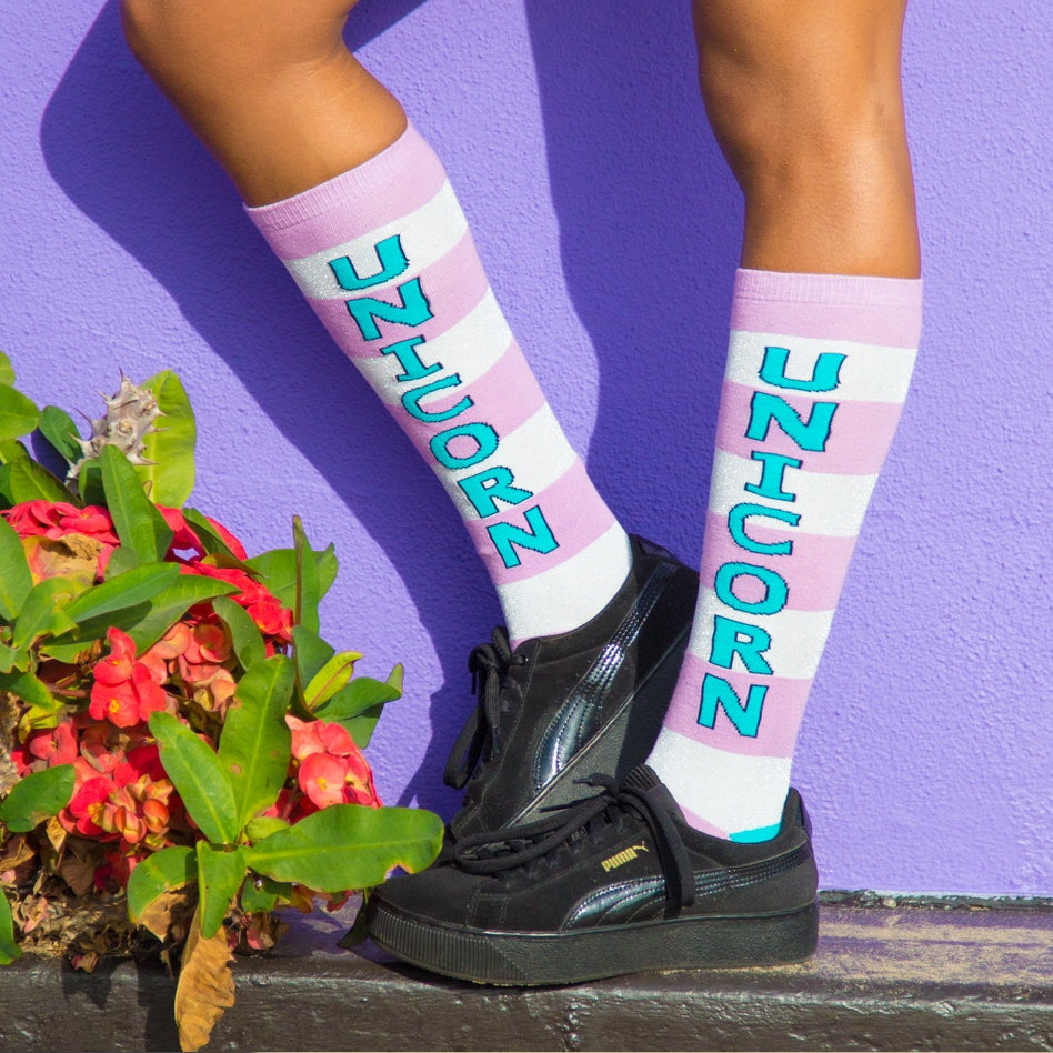 Lifestyle shot showing the socks worn with black platform sneakers against a purple wall. [lf]