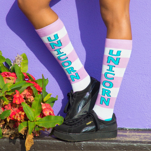 Lifestyle shot showing the socks worn with black platform sneakers against a purple wall. [lf]
