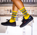 Lifestyle shot of a person wearing the True Crime socks with black shoes. The socks are partially visible. [lf]