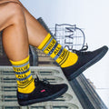 Another lifestyle shot showcasing the True Crime socks on a person's feet, this time with the socks slightly higher up the leg. [lf]