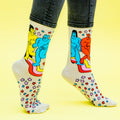 A close-up flat lay of 'Star Gazing' socks on a yellow background showing the detailed design. [lf]