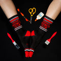 Lifestyle shot of a pair of Satan's Crafting Club socks worn with crafting supplies arranged around them. [lf]